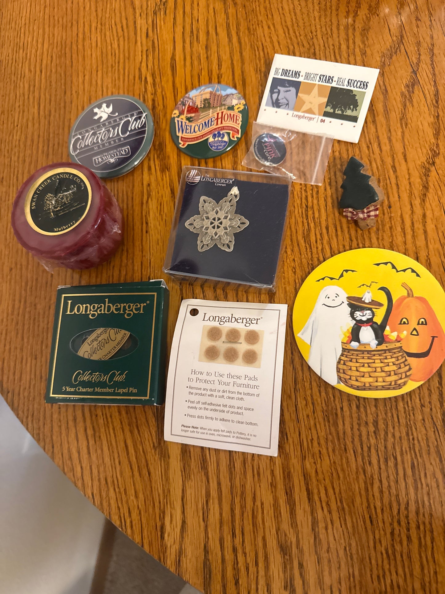 Longaberger and homestead items sold as a lot ( pewter star ornament, Halloween coaster, various pins, felt pads, and a candle)
