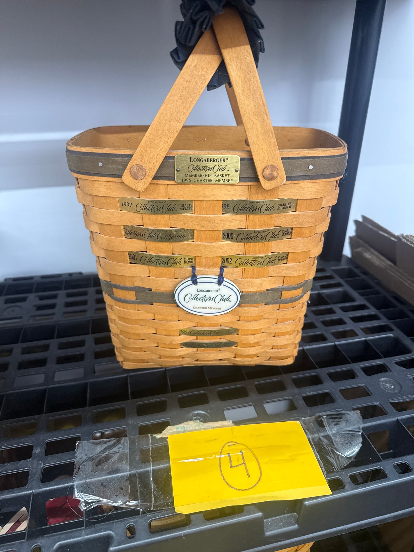 Longaberger collectors club membership basket with tie on, handle gripper, and year plates in basket